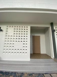 a white door with a window on a building at PRIMENINe in Ban Ru Sa Mi Lae