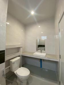 a white bathroom with a toilet and a sink at PRIMENINe in Ban Ru Sa Mi Lae