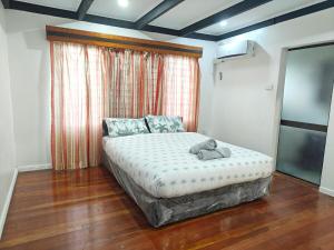 a bedroom with a bed with a teddy bear on it at 3 bedroom fully air conditioned family home -spacious, free parking in Suva