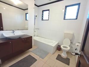 a bathroom with a sink and a toilet and a bath tub at 3 bedroom fully air conditioned family home -spacious, free parking in Suva +19 photos