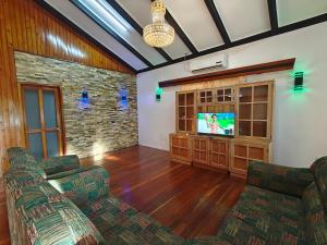 a living room with two chairs and a flat screen tv at 3 bedroom fully air conditioned family home -spacious, free parking in Suva