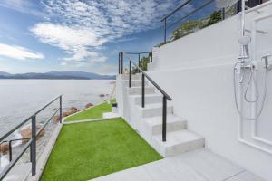 a staircase with a walk in shower and green grass at Namioto Villa YOSA in Hama