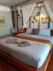a bedroom with two beds with towels on it at Baan I Ta Lay Koh Yao Noi in Ko Yao Noi