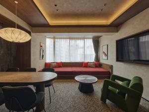 a living room with a red couch and a table at illi Haku Asakusa in Tokyo