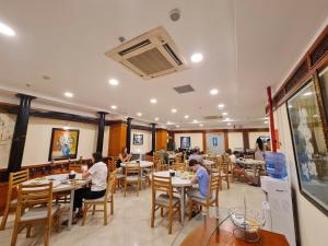 a group of people sitting at tables in a restaurant at Media Nha Trang Hotel in Nha Trang