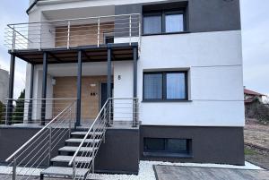 a white building with a staircase in front of it at Apartamenty w Domu Bezpieczna Przystań in Frombork