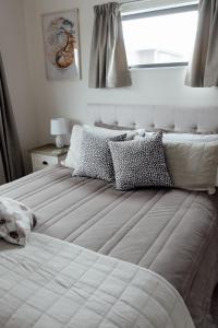 a white bed with pillows on it in a bedroom at Pembroke View in Carterton