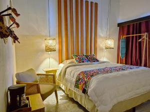 a bedroom with a large bed and a chair at Luna Maya Boutique Hotel in Antigua Guatemala