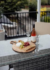 a table with a plate of wine and wine glasses at Pembroke View in Carterton