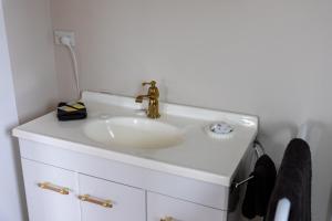 a white bathroom sink with a gold faucet at Pembroke View in Carterton +16 photos