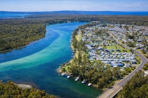 an aerial view of a resort on a river at Badgee Park in Sussex Inlet +23 photos