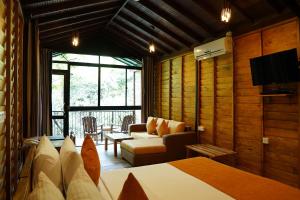 a hotel room with a bed and a couch at The Glenrock Wellness Nature Resort in Belihuloya