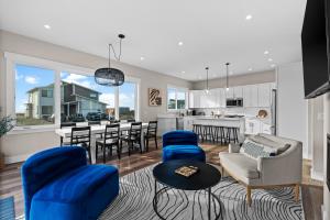 a living room with blue chairs and a kitchen at The Oceanview Retreat in Westport