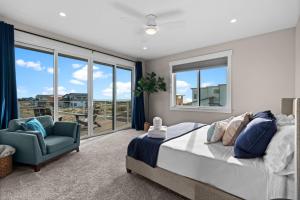a bedroom with a bed and a chair and windows at The Oceanview Retreat in Westport