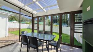 a conservatory with a glass table and chairs at The Dock in Clarens