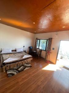a bedroom with a bed in a room with wooden floors at ITW - Into The Wild , Viratkhai , Chakrata in Lakhwār