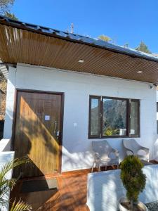 a house with a patio with a sliding glass door at ITW - Into The Wild , Viratkhai , Chakrata in Lakhwār