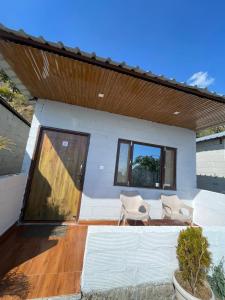 a patio with two chairs and a house at ITW - Into The Wild , Viratkhai , Chakrata in Lakhwār +13 photos