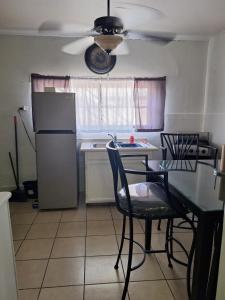 a kitchen with a table and chairs and a refrigerator at Casa en La zona Centro de la Ciudad in Ciudad Juárez