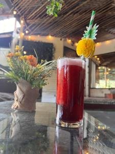 a drink in a glass sitting on a table at CARIBbEAN Paradise Hotel in Lanquín