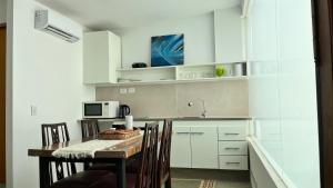 a kitchen with a table with chairs and a microwave at DEPARTAMENTO dos dormitorios en Martinez, cercano a CABA, zona clinicas y oficinas, con AA y Wifi, ideal familias in Martínez