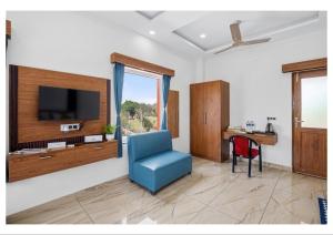 a living room with a blue chair and a television at RS Resort in Ayodhya