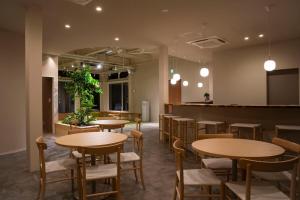 a restaurant with tables and chairs and a bar at 水の郷リトリート 再 in Katori