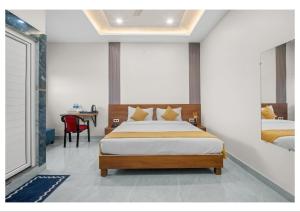 a bedroom with a bed and a table with a chair at RS Resort in Ayodhya