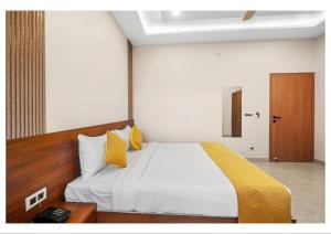 a bedroom with a large white bed with yellow pillows at RS Resort in Ayodhya +33 photos