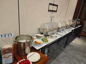a buffet line with plates of food on a table at Saint Meiya Apartment Hotel- Nr Line8 & Line11 Pazhou STN-Walk to Canton Fair in Guangzhou