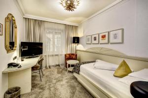 a hotel room with a bed and a desk at Hotel Goldener Adler, BW Signature Collection in Innsbruck