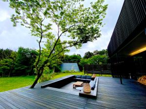 a patio with two chairs and a table and a tree at MONS GORA Luxury Private Villa with Onsen Hakone Gora in Hakone
