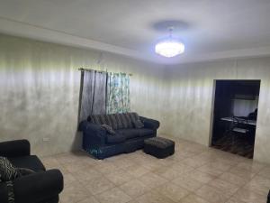 a living room with a couch and a table at Stays at Global Dreams in Beckford Town
