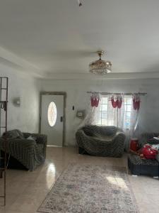 a living room with a couch and a bed and windows at Stays at Global Dreams in Beckford Town