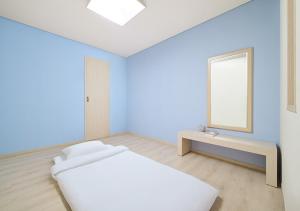 a white room with a bed and a mirror at Hanwha Resort Daecheon Paros in Boryeong +21 photos