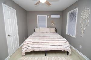 a bedroom with a bed with a striped blanket at Home Sweet Home Bungalow in North Little Rock +5 photos