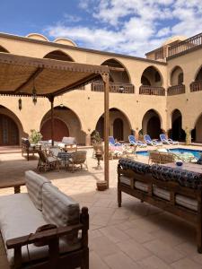 a patio with lounge chairs and a swimming pool at Sultana Palace in ‘Ezbet Abu Ḥabashi