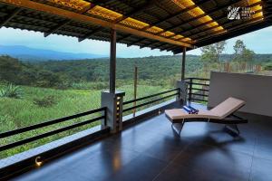a chair on a balcony with a view of a mountain at The Green Hive Villas in Belgaum