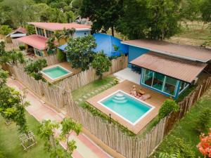 an aerial view of a house with two swimming pools at Mondara Villa and Glamping in Ban Bo Wi