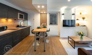 a kitchen with a table and a living room at Studio neuf et moderne centre historique in Chambéry +6 photos