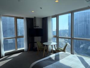 a hotel room with a bed and a table and chairs at 센텀스위트호텔 in Busan +14 photos