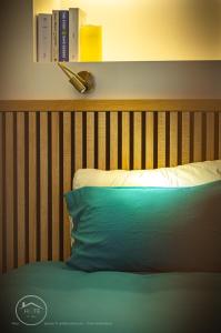 a bed with a wooden headboard and a blue pillow at Studio neuf et moderne centre historique in Chambéry