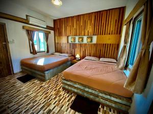 a bedroom with two beds in a room at Sarita Resort Villa in Kampong Huaibū