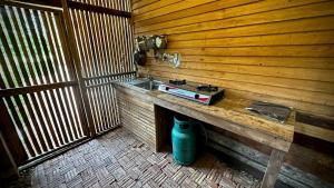 a room with a wooden paneled wall with a counter with a stove at Sarita Resort Villa in Kampong Huaibū +6 photos