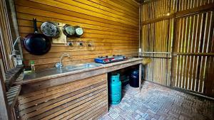 a kitchen with a sink in a wooden wall at Sarita Resort Villa in Kampong Huaibū