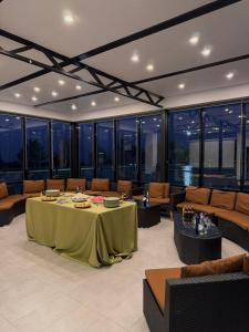 a large room with a table and couches and windows at Arman Dala Resort in Qaskeleng
