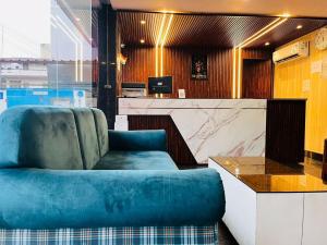 a living room with a blue couch and a counter at Hotel Wisteria Haridwar in Haridwār
