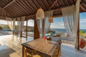 a room with a table with a view of the ocean at Dolce Vita Villa in Sampalan
