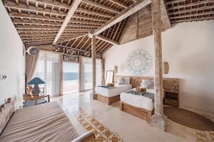 a bedroom with two beds in a room with the ocean at Dolce Vita Villa in Sampalan +11 photos