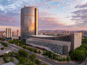 a tall building in a city with a street at Sheraton Jinzhou Hotel in Jinzhou